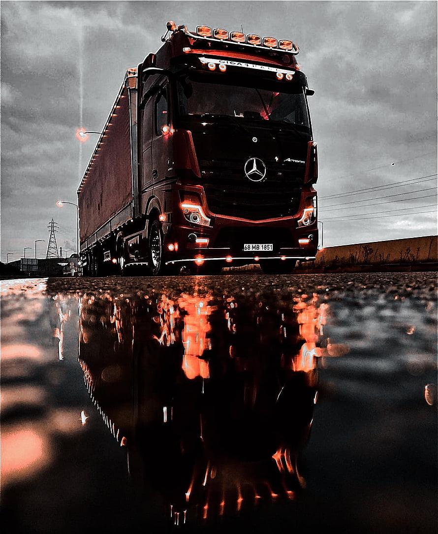 Mercedes-Benz Actros Semi Truck with Reflection in Puddle Under Dramatic Sky HD phone wallpaper