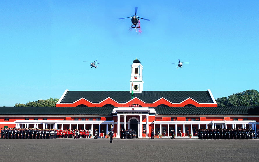 Indian Military Academy Dehradun with helicopters flying over the historic red and white building HD wallpaper