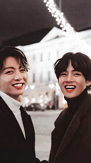 BTS Taekook smiling together in a European city street at night HD phone wallpaper
