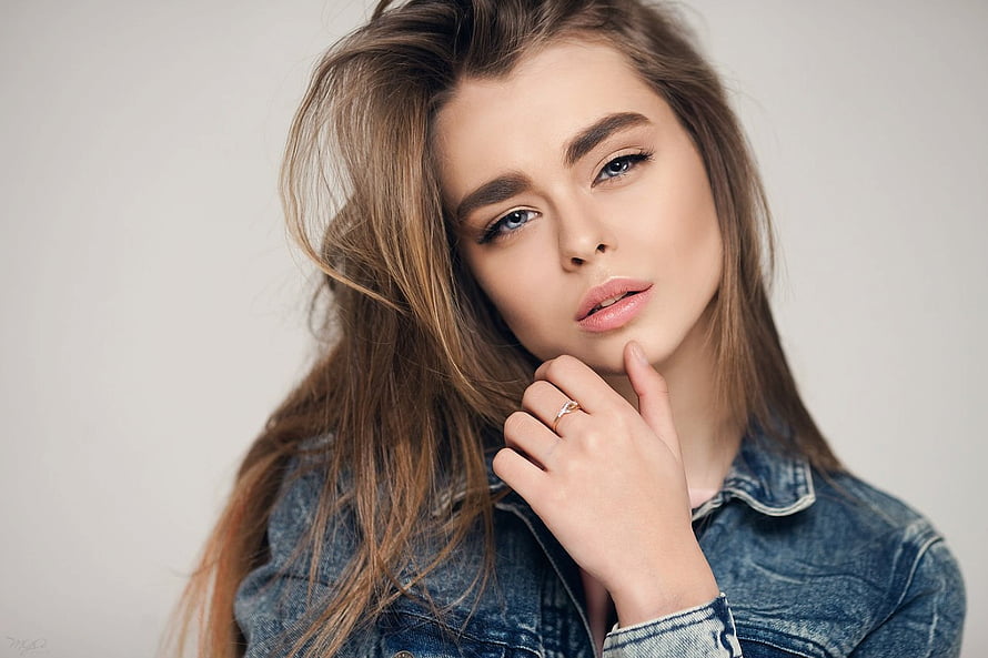 Studio Portrait of a Young Woman in a Denim Jacket with Windblown Hair HD wallpaper