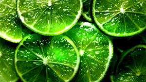 Vibrant Green Lime Slices Close-Up with Glistening Citrus Texture HD wallpaper