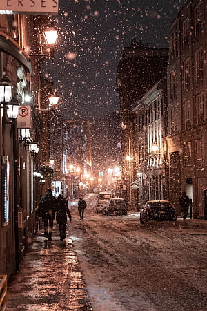 Snowy City Street at Night with Pedestrians and Warm Streetlights HD phone wallpaper
