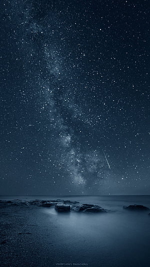 Milky Way Galaxy Over a Dark Ocean Shoreline with a Shooting Star HD phone wallpaper
