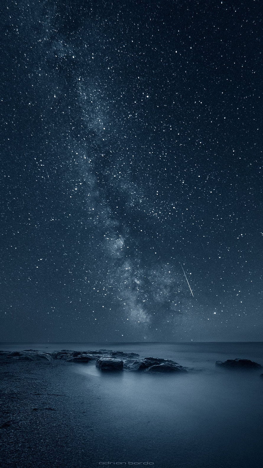 Milky Way Galaxy Over a Dark Ocean Shoreline with a Shooting Star HD phone wallpaper