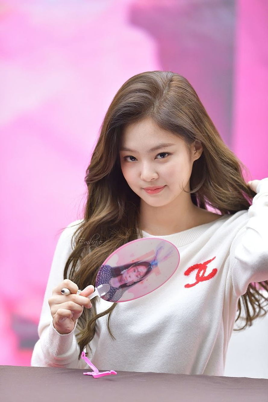 Jennie Kim from Blackpink holding a pink fan at a promotional event HD phone wallpaper