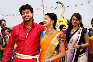 Vijay and Trisha in traditional attire during a festive procession scene from the Tamil film Velayudham HD wallpaper