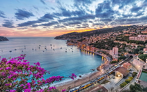 French Riviera Coastal Town at Sunset with Bougainvillea and Harbor Boats HD wallpaper