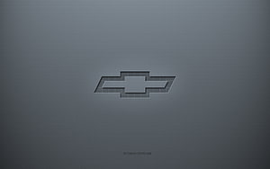 Chevrolet Bowtie Emblem on Textured Gray Surface with Subtle 3D Depth and Minimalist Design HD wallpaper