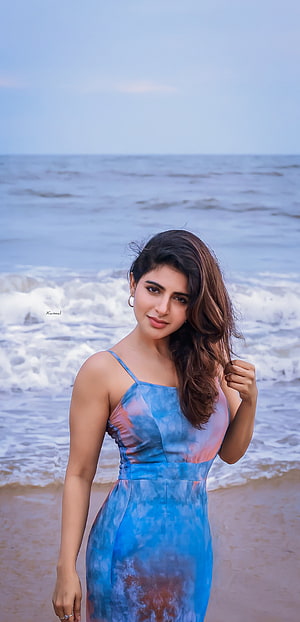 Iswarya Menon in a Blue Tie-Dye Dress on a Beach with Ocean Waves HD phone wallpaper