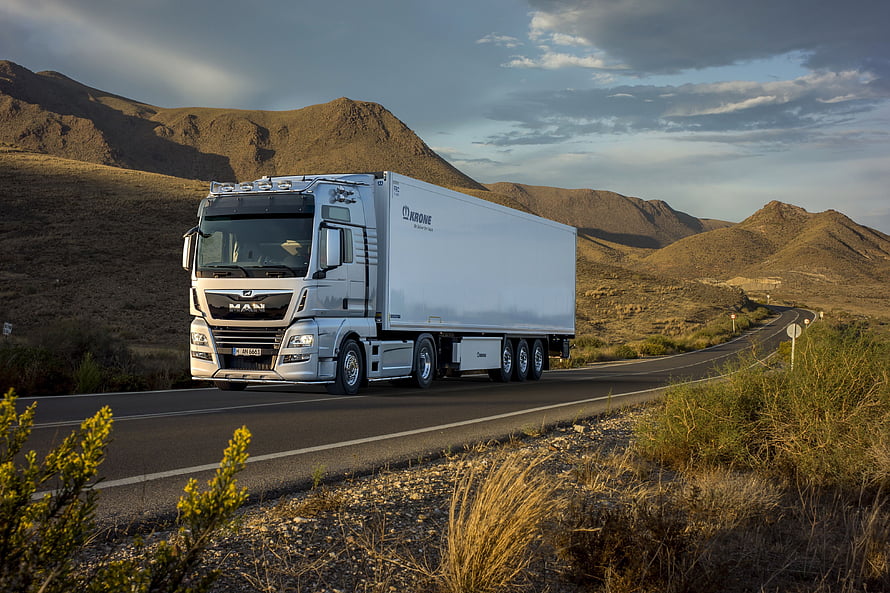 Silver MAN TGX Semi Truck with Krone Trailer Driving on Mountain Highway HD wallpaper
