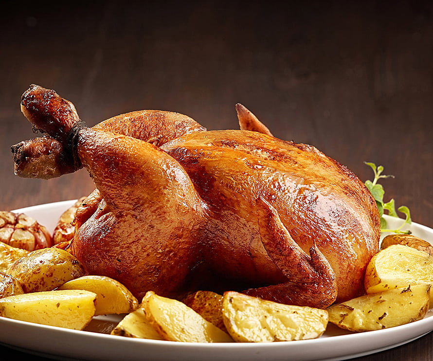 Golden Roast Chicken with Crispy Potatoes and Garlic on a White Platter HD wallpaper
