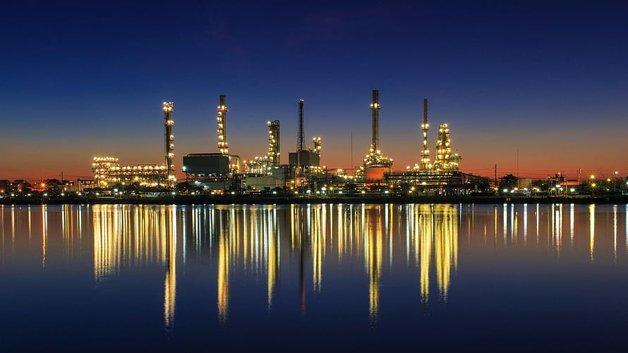 Illuminated Oil Refinery Complex Reflected in Calm Water at Dusk HD wallpaper