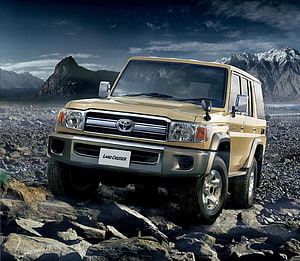 Gold Toyota Land Cruiser 70 Series on Rocky Mountain Terrain HD wallpaper