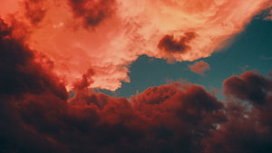 Dramatic Crimson Clouds Against a Deep Teal Sky at Sunset HD wallpaper