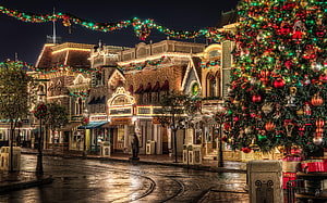 Disneyland Main Street Christmas Night Scene with Ornamented Tree and Victorian Architecture HD wallpaper