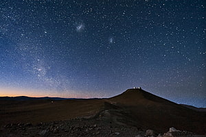 Milky Way Galaxy Arching Over a Desert Mountain at Night with Observatory Domes HD wallpaper