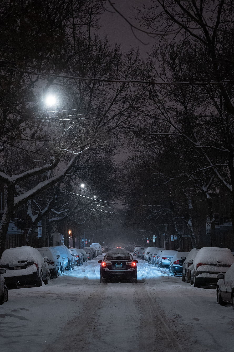 Snow-Covered City Street at Night with Parked Cars and Glowing Streetlights HD phone wallpaper
