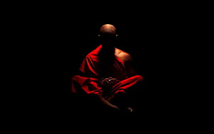 Buddhist Monk in Red Robe Meditating in Darkness HD wallpaper