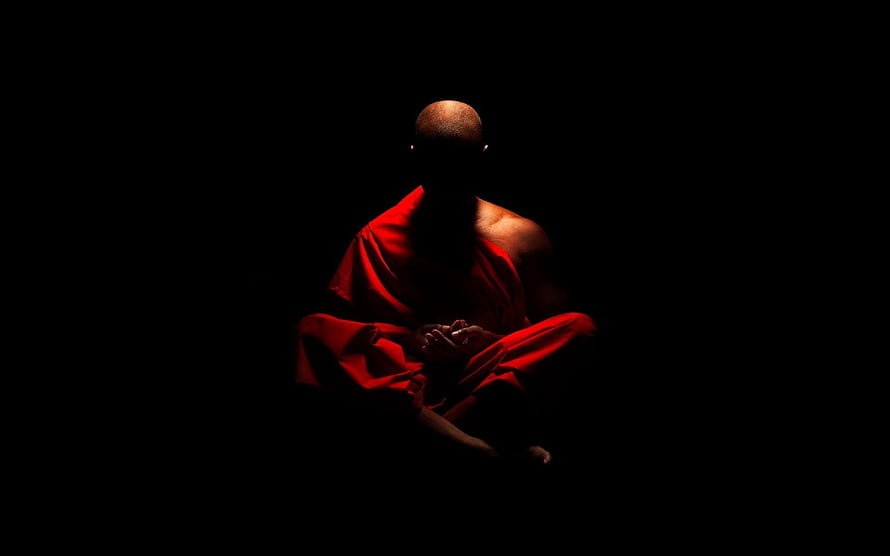Buddhist Monk in Red Robe Meditating in Darkness HD wallpaper