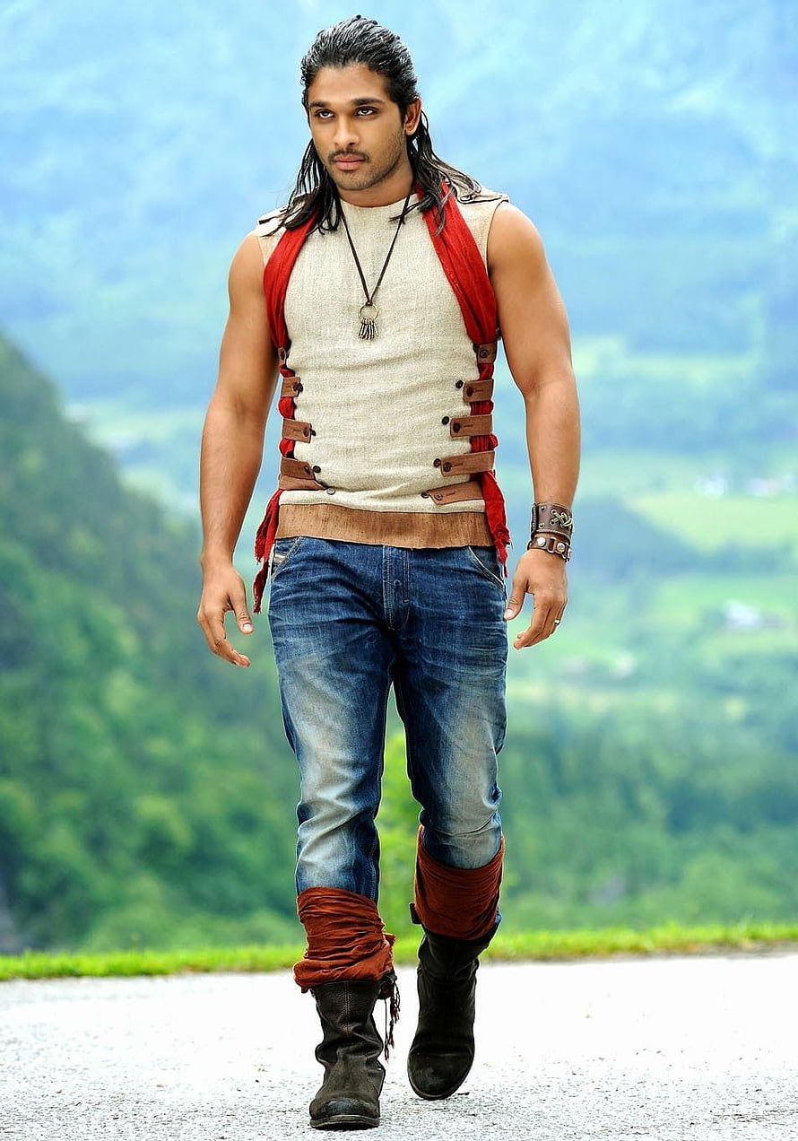 Allu Arjun in rustic warrior costume walking on a mountain road with green hills in the background HD phone wallpaper