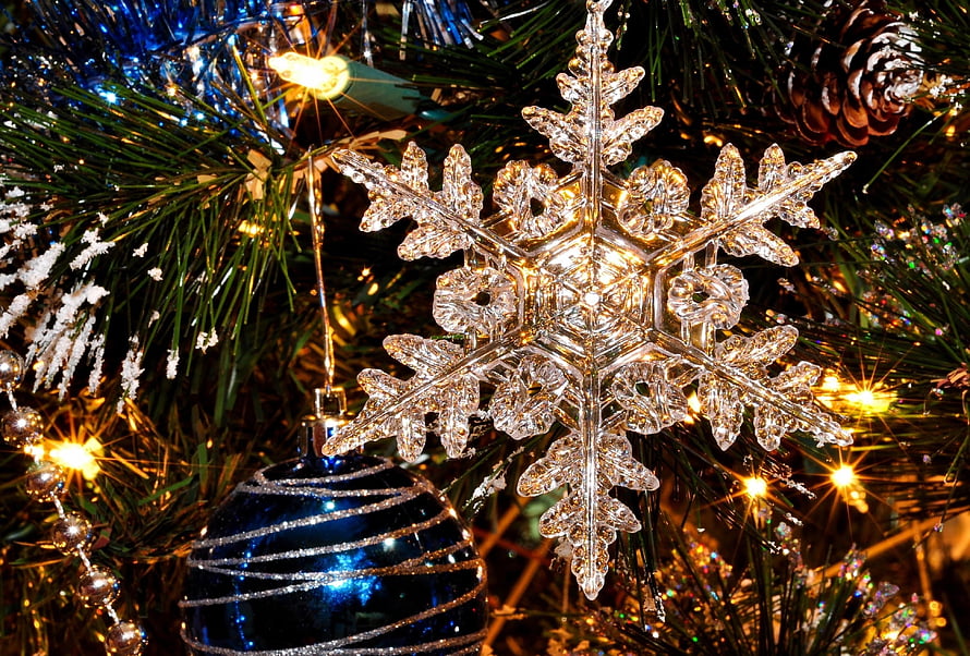 Crystal Snowflake Ornament on a Festive Christmas Tree with Warm Lights and Pine Cones HD wallpaper