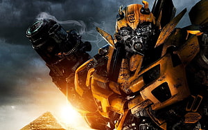 Bumblebee from Transformers in a battle-worn pose with a smoking cannon against a dramatic stormy sky HD wallpaper