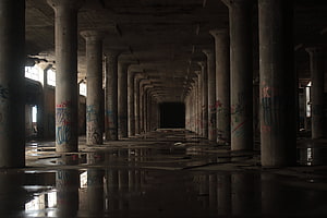 Dark Abandoned Warehouse Interior With Flooded Concrete Floors And Graffiti Covered Pillars HD wallpaper