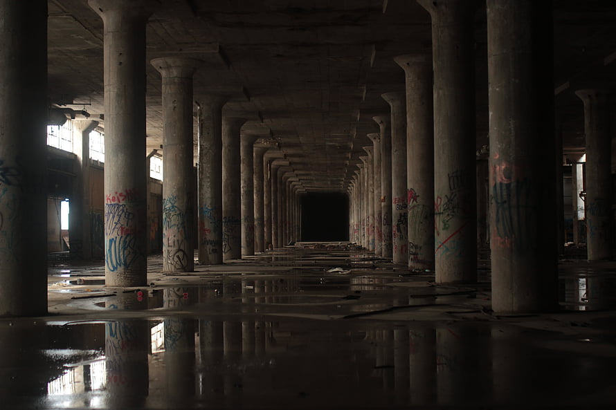Dark Abandoned Warehouse Interior With Flooded Concrete Floors And Graffiti Covered Pillars HD wallpaper