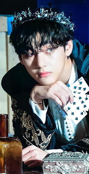 V from BTS in ornate crown and black velvet attire holding playing cards HD phone wallpaper