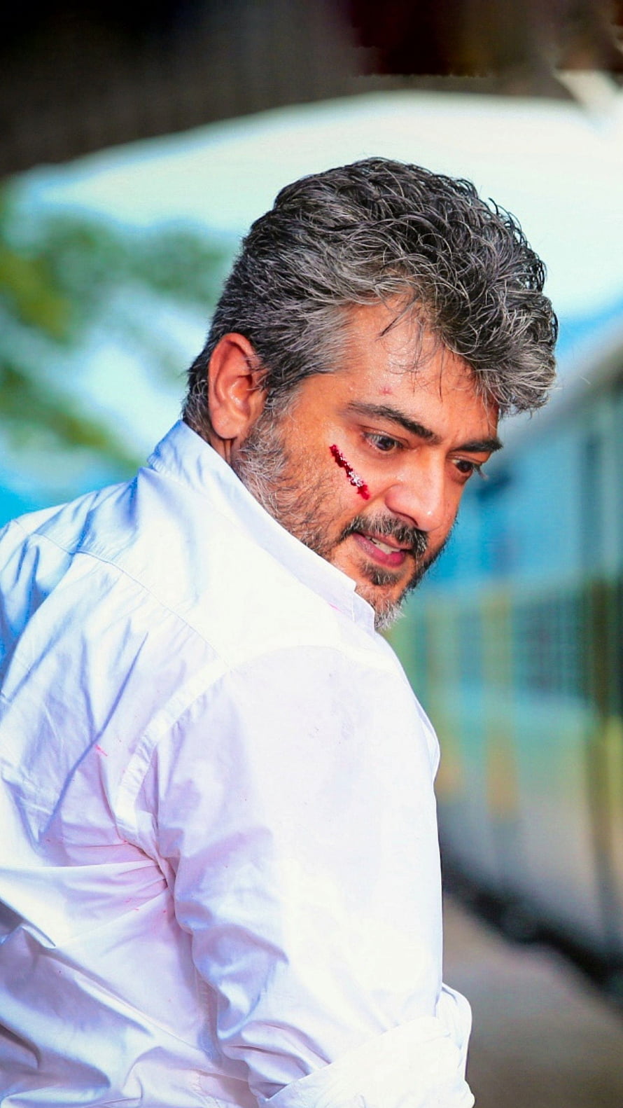 Ajith Kumar in a dramatic scene with a facial injury and white shirt HD phone wallpaper