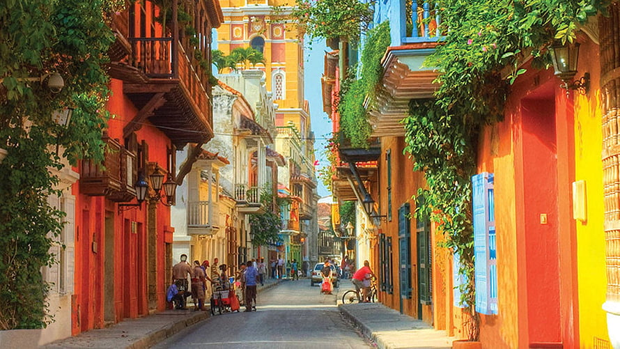 Vibrant Colonial Street Scene in Cartagena, Colombia with Colorful Buildings and Lush Greenery HD wallpaper