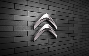 Citroën 3D chrome logo mounted on a dark gray brick wall with dramatic lighting HD wallpaper