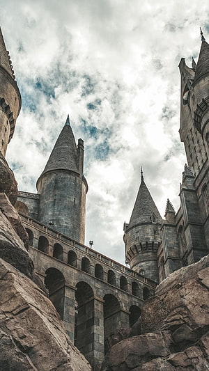 Hogwarts Castle Turrets and Stone Arches Under a Dramatic Cloudy Sky HD phone wallpaper