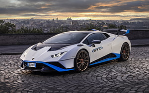 White Lamborghini Huracan STO with Blue Accents Parked on Cobblestones at Sunset HD wallpaper