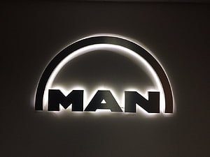 Illuminated MAN Trucks Logo on Dark Wall with Backlit Arch Design HD wallpaper
