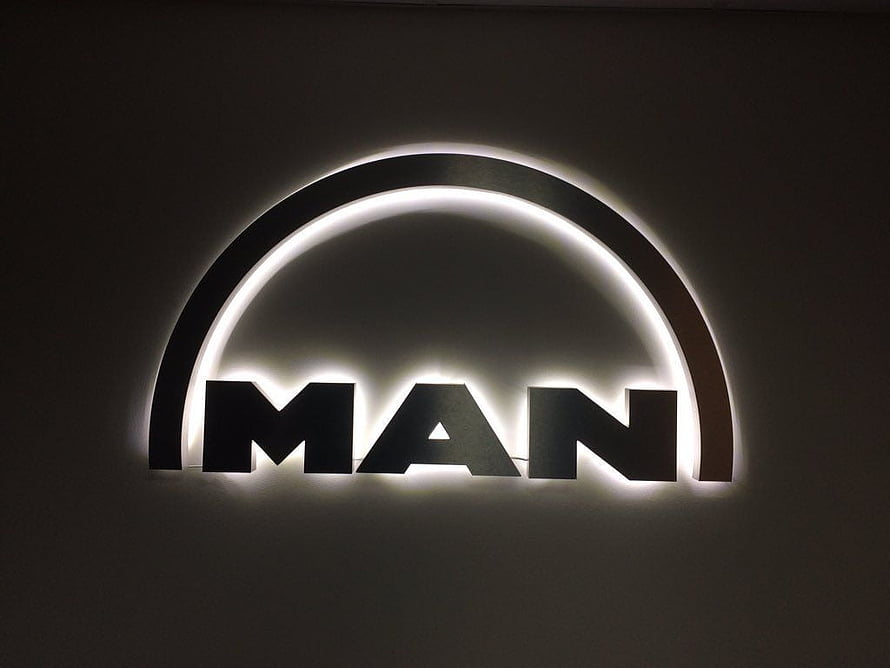 Illuminated MAN Trucks Logo on Dark Wall with Backlit Arch Design HD wallpaper