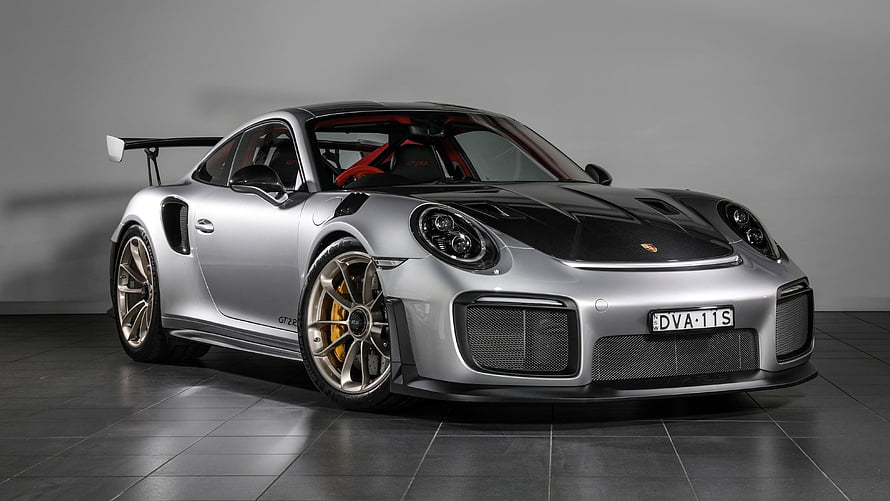 Silver Porsche 911 GT3 RS with black carbon hood and rear wing in studio HD wallpaper