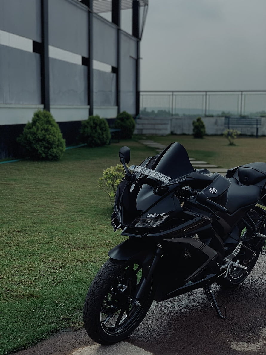 Black Yamaha R15 V4 Sportbike Parked on Grass with Modern Building Background HD phone wallpaper