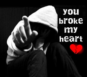 Emotional Black and White Portrait of a Hooded Figure Pointing with Broken Heart Text Overlay HD wallpaper