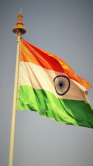 Indian National Flag Waving on a Tall Pole Against a Clear Blue Sky HD phone wallpaper