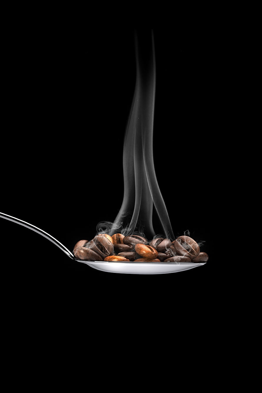 Steaming roasted coffee beans resting in a silver spoon against a dark background HD phone wallpaper