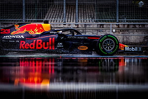 Red Bull Racing Formula 1 car on wet track with water spray and reflection HD wallpaper