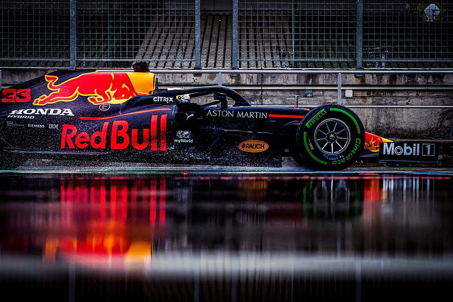 Red Bull Racing Formula 1 car on wet track with water spray and reflection HD wallpaper