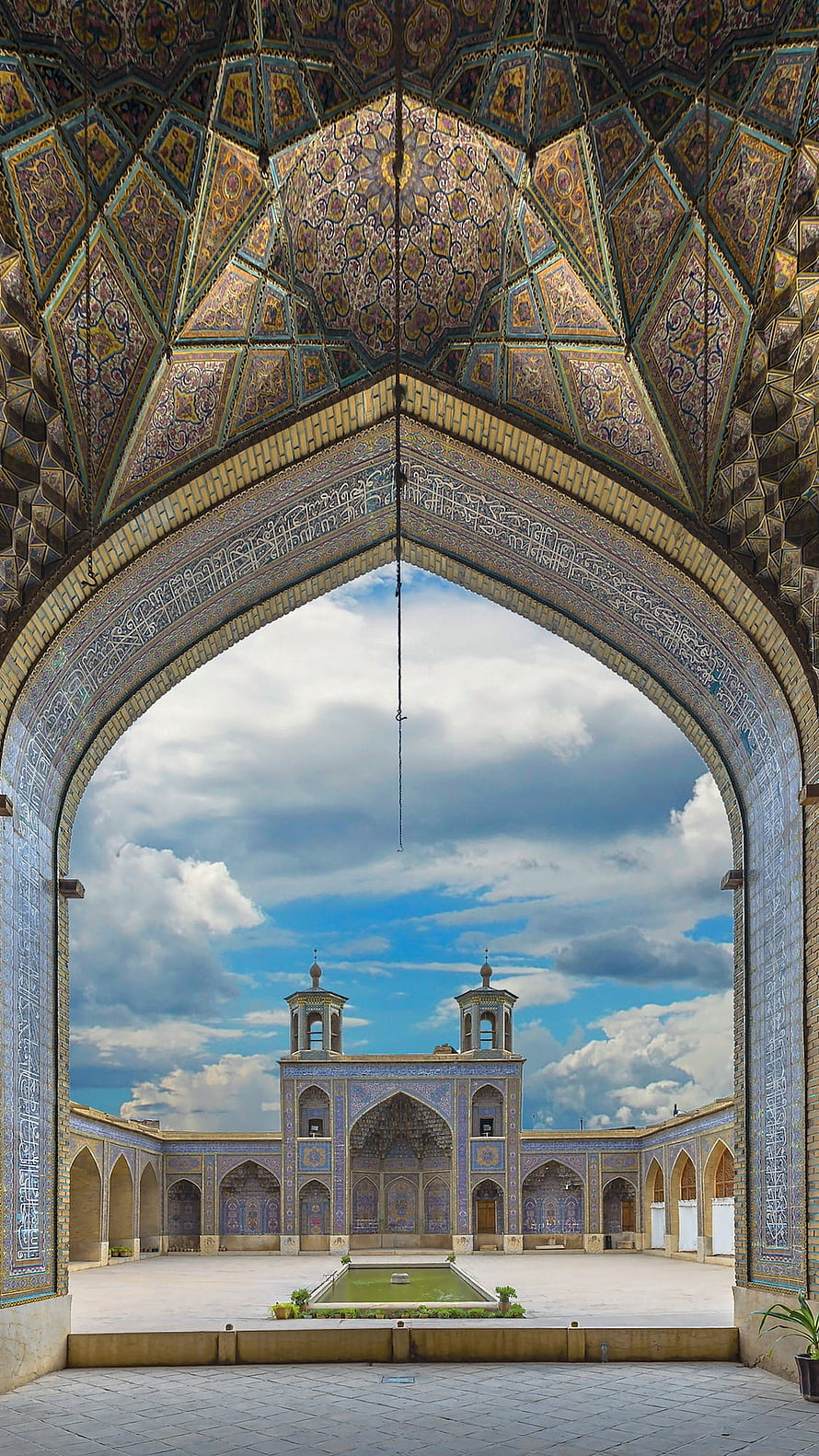 Ornate Islamic Archway Framing a Majestic Mosque Courtyard with Central Fountain HD phone wallpaper