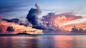 Dramatic Sunset Over Calm Sea With Silhouetted Island And Vibrant Clouds HD wallpaper