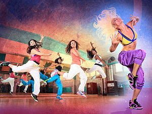 Energetic Zumba Dance Class with Women Jumping in a Studio HD wallpaper