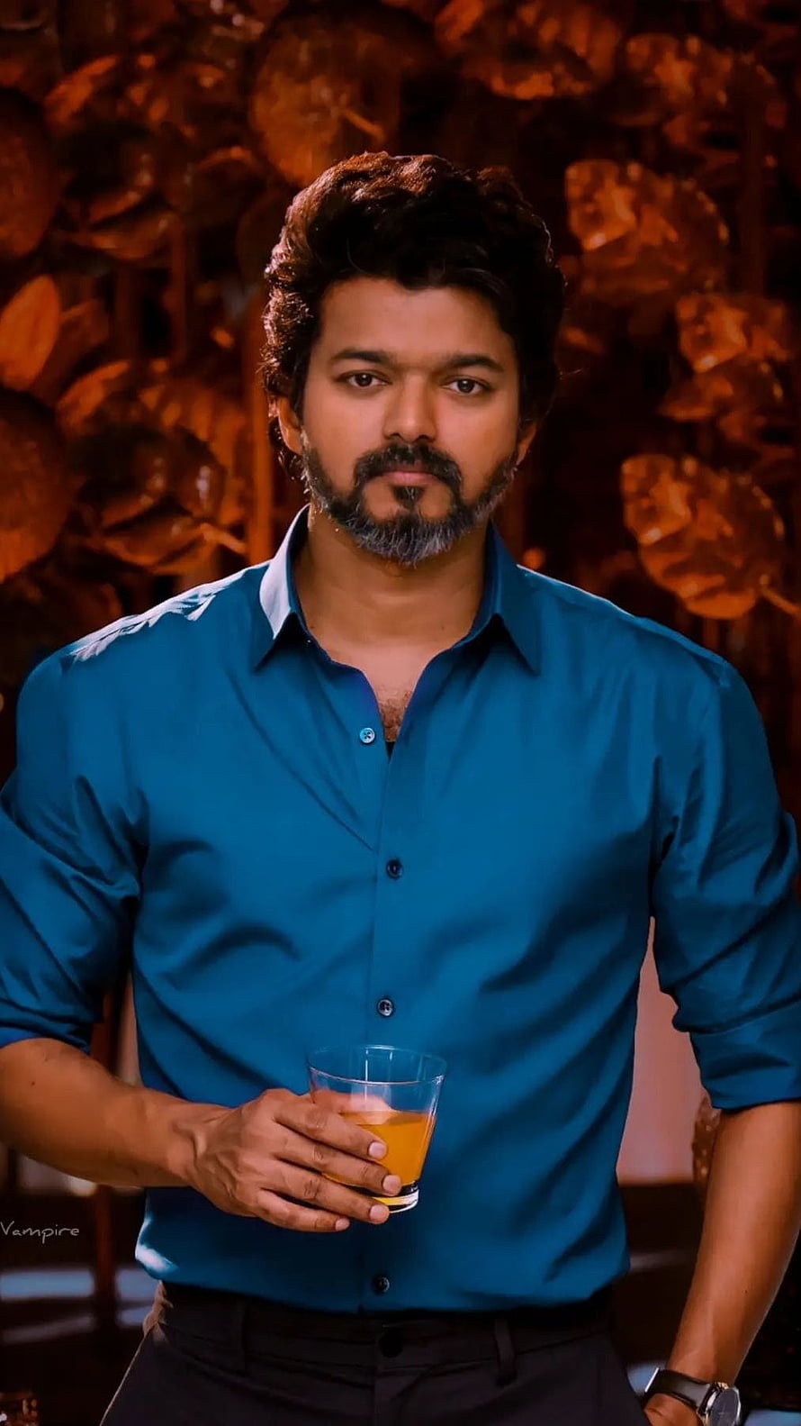 Thalapathy Vijay in a teal shirt holding a glass of juice against a warm textured background HD phone wallpaper