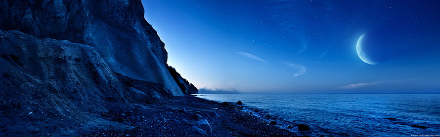 Serene Nighttime Coastal Cliffs Under a Crescent Moon and Starry Sky HD wallpaper