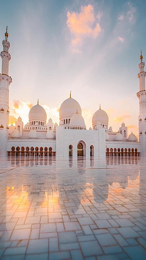 Sheikh Zayed Grand Mosque in Abu Dhabi at sunset with golden sky and reflective marble courtyard HD phone wallpaper