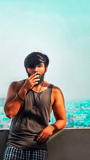 Dhruv Vikram and Adithya Varma in a moody rooftop portrait with a hazy city skyline HD phone wallpaper
